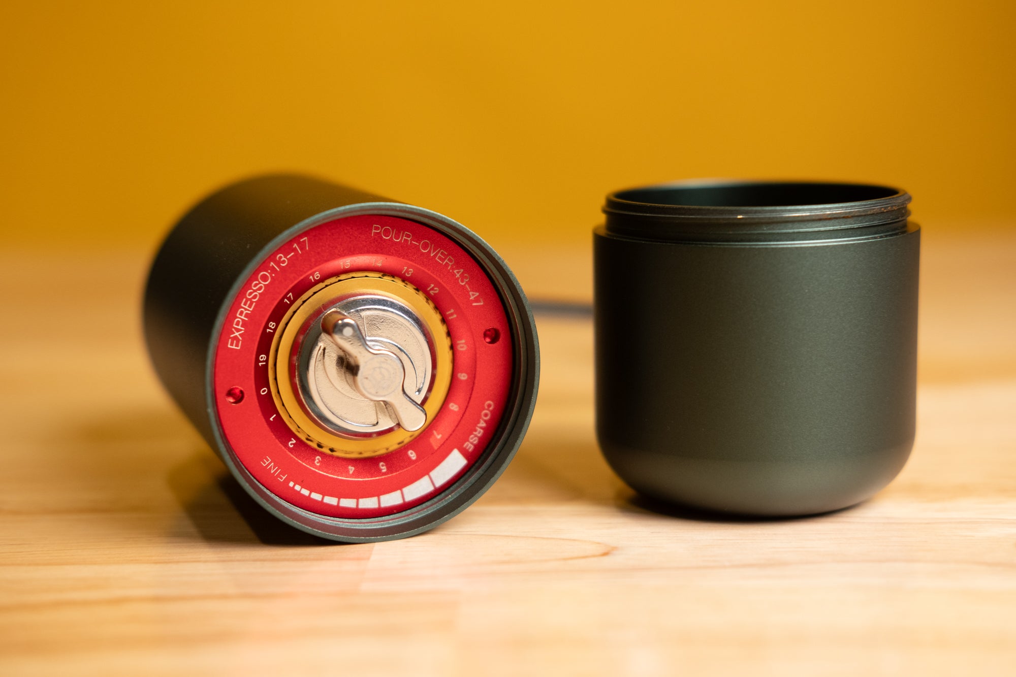 LAMOSE zeroHero Z7 manual coffee grinder in dark green, showing red grind settings for espresso & pour-over, metal body, low angle view.