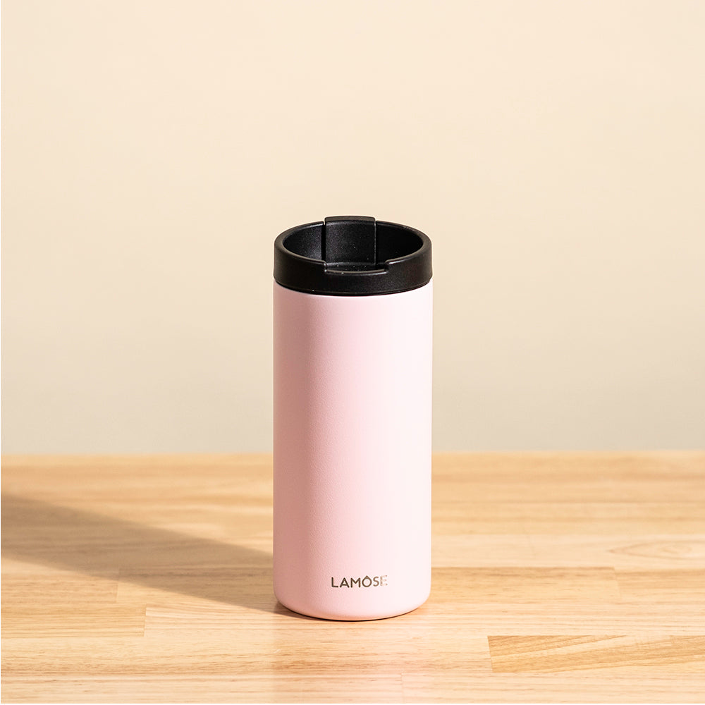 LAMOSE Grouse 12 oz insulated tumbler in baby pink, with a black leakproof lid, shown front view on a wooden table.